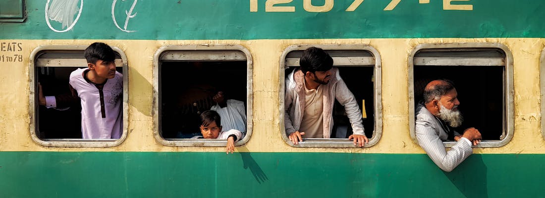 People looking out of the windows of a train in Pakistan