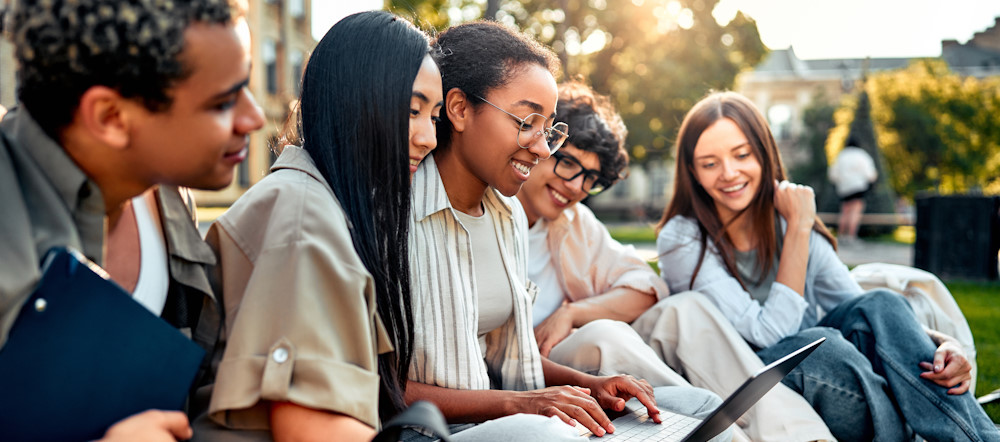 diverse group of teens using a laptop